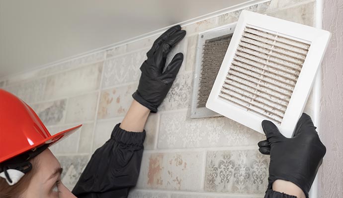 Person inspecting air duct dust for cleaning Person inspecting dust inside air duct system before cleaning