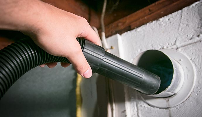 Professional worker cleaning dryer vent