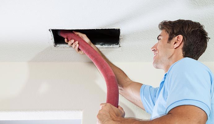 Person cleaning air duct