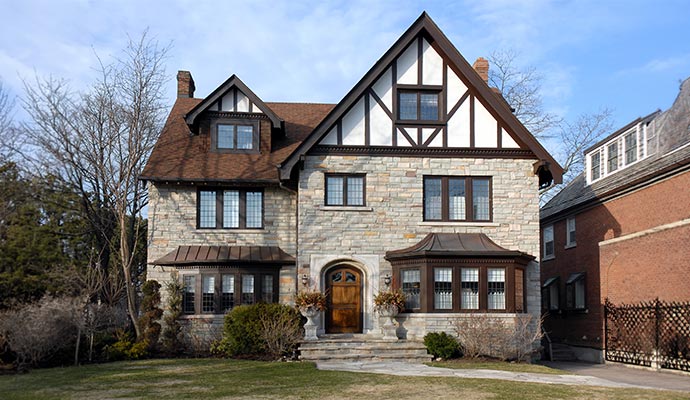 Large traditional stone house with Tudor style accents.