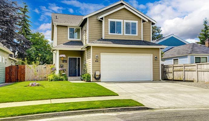 Two-story home with garage and green lawn.