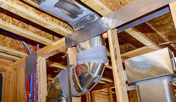 Mastic sealed metal air ducts in home attic.