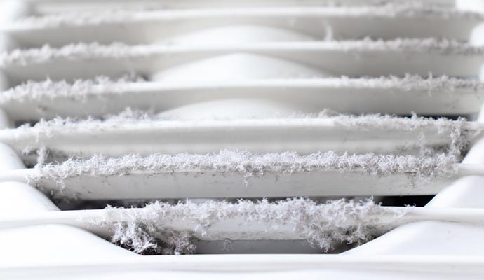 extremely dirty and dusty white plastic ventilation air grille at home close up