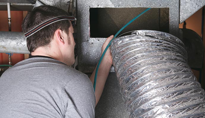 Duct repair and replacement services in progress Technician repairing and replacing damaged air ducts