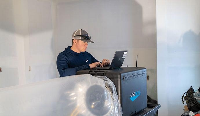 Technician using Aeroseal equipment for duct sealing