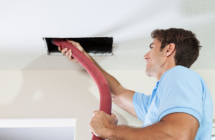 Professional worker cleaning duct