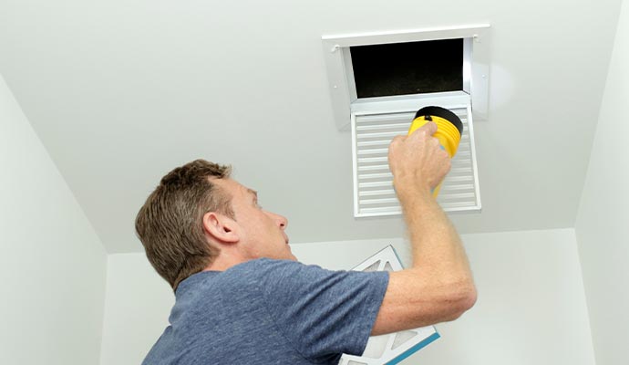 Man inspecting air duct