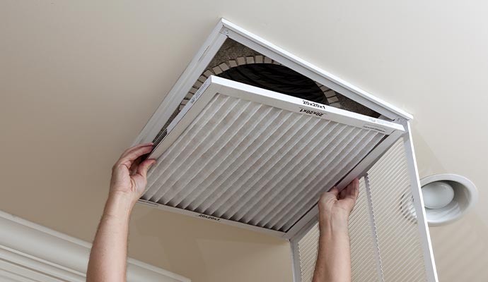 Residents' air ducts are being cleaned by a worker.