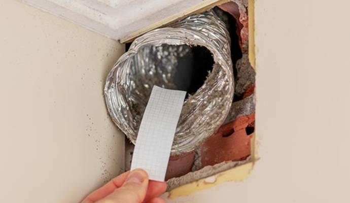 Technician testing residential air duct leaks.