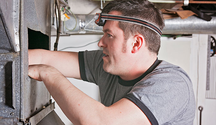 Technician inspecting and cleaning HVAC ductwork