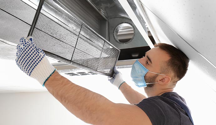 worker cleaning air duct